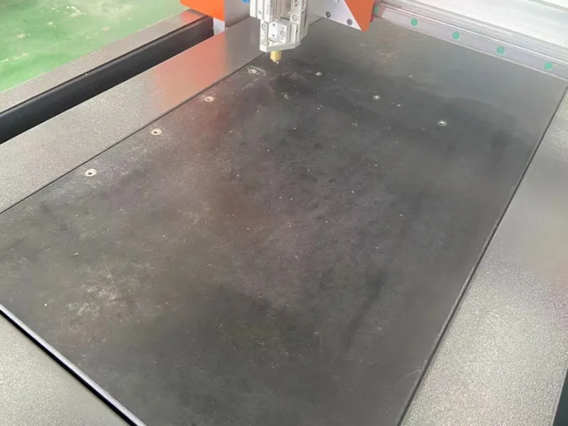 Мраморный стол с небольшими отверстиями, которые всасывают стекло во время резки, чтобы обеспечить стабильность стекла.